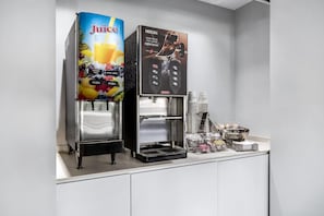 A juice dispenser and a Nescafe coffee machine in a commercial setting.