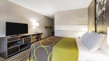 Une chambre d’hôtel avec un lit, une télévision, un bureau et une chaise.