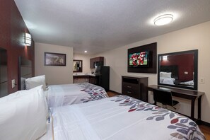 A hotel room with two beds, a desk, a television, and a bathroom. - Red Roof Inn Morgan City (Morgan City)