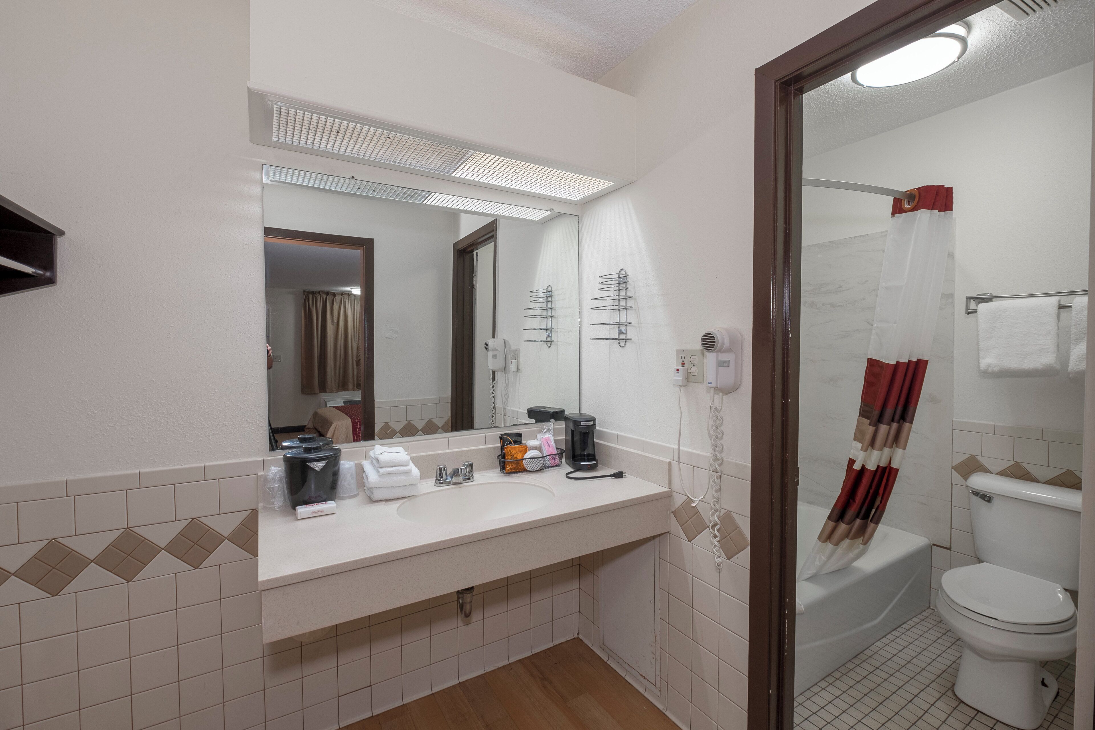 A bathroom with a sink, mirror, and toilet.