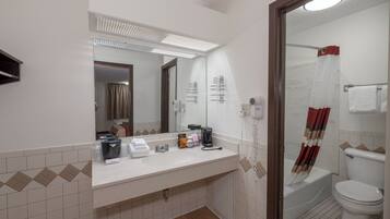 A bathroom with a sink, mirror, and toilet.