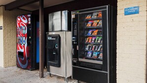 A vending machine and a soda dispenser outside a building. - Red Roof Inn Morgan City (Morgan City)
