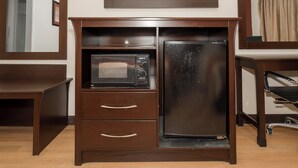 A compact kitchenette with a microwave and a refrigerator built into a wooden cabinet. - Red Roof Inn Morgan City (Morgan City)