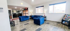 A hotel lobby with blue sofas, a reception desk, and a window with a view.