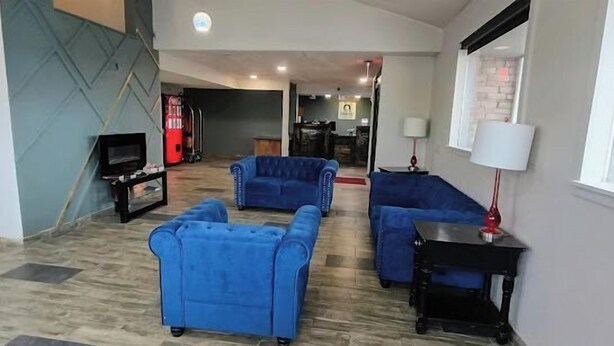 Una sala de estar con sofás azules, una mesa negra y un televisor.