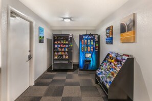 A hallway with vending machines, a bookcase, and a door. - Motel 6 New Haven - Branford, CT (Branford)