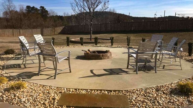 An outdoor seating area with metal chairs and a fire pit. - Motel 6 White, GA - Cartersville (White)