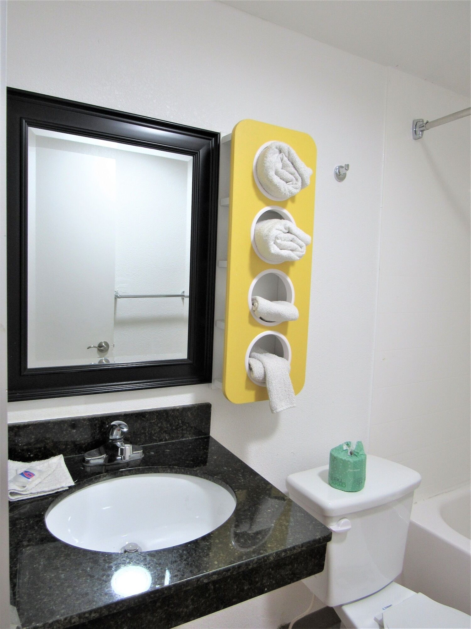 A bathroom with a sink, mirror, toilet, and towel rack.