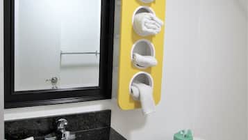A bathroom with a sink, mirror, toilet, and towel rack.