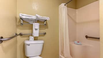 A bathroom with a toilet, a shower with a curtain, and a towel rack with towels.