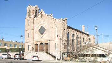 A historic stone building with a central arched window and a bell tower.