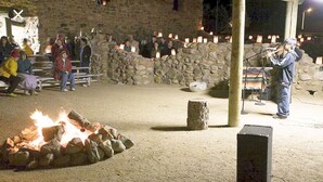 A stone building with a fire pit in the center, surrounded by people. - Americas Best Value Inn Globe AZ (Globe)