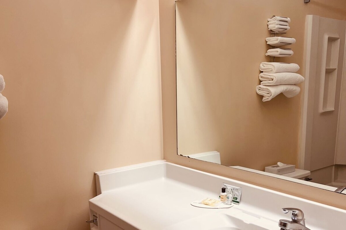 Une salle de bain avec un lavabo blanc, un miroir et des toilettes.