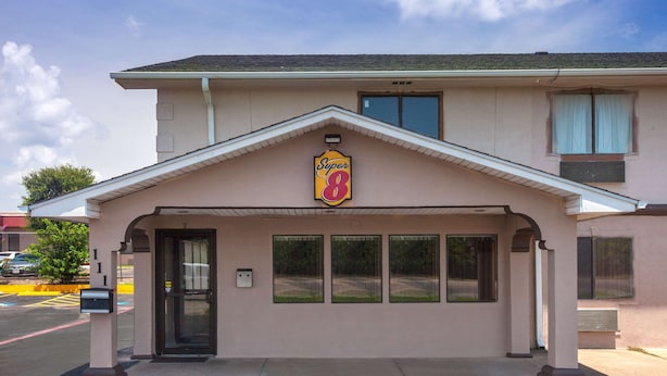 A Super 8 motel with a single-story structure, a covered entrance, and a parking lot in the background.