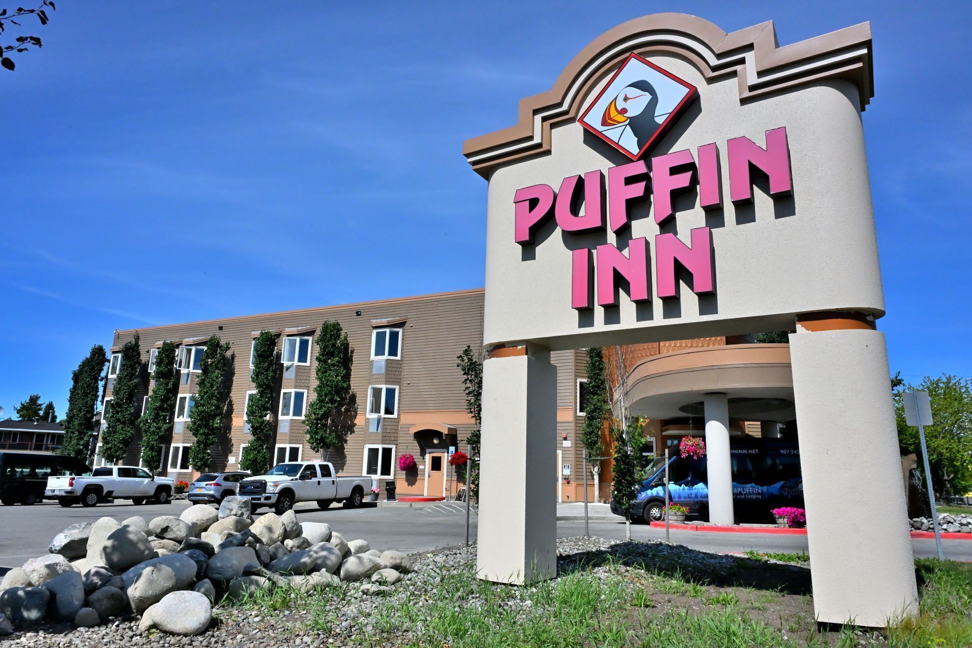 A sign for the Puffin Inn hotel with a clear view of the building in the background.