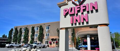 A sign for the Puffin Inn hotel with a clear view of the building in the background.