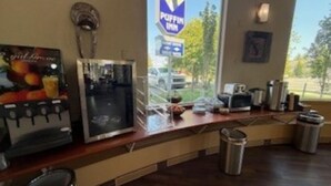 A kitchenette with a coffee machine, a microwave, and a trash bin.