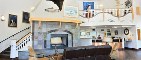 Eine geräumige Lobby mit Kamin aus Stein, Ledersitzmöglichkeiten und einem Empfangstresen.