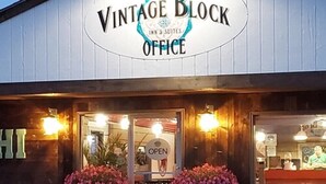 The exterior of Vintage Block Inn & Suites Office with a sign indicating it's open.
