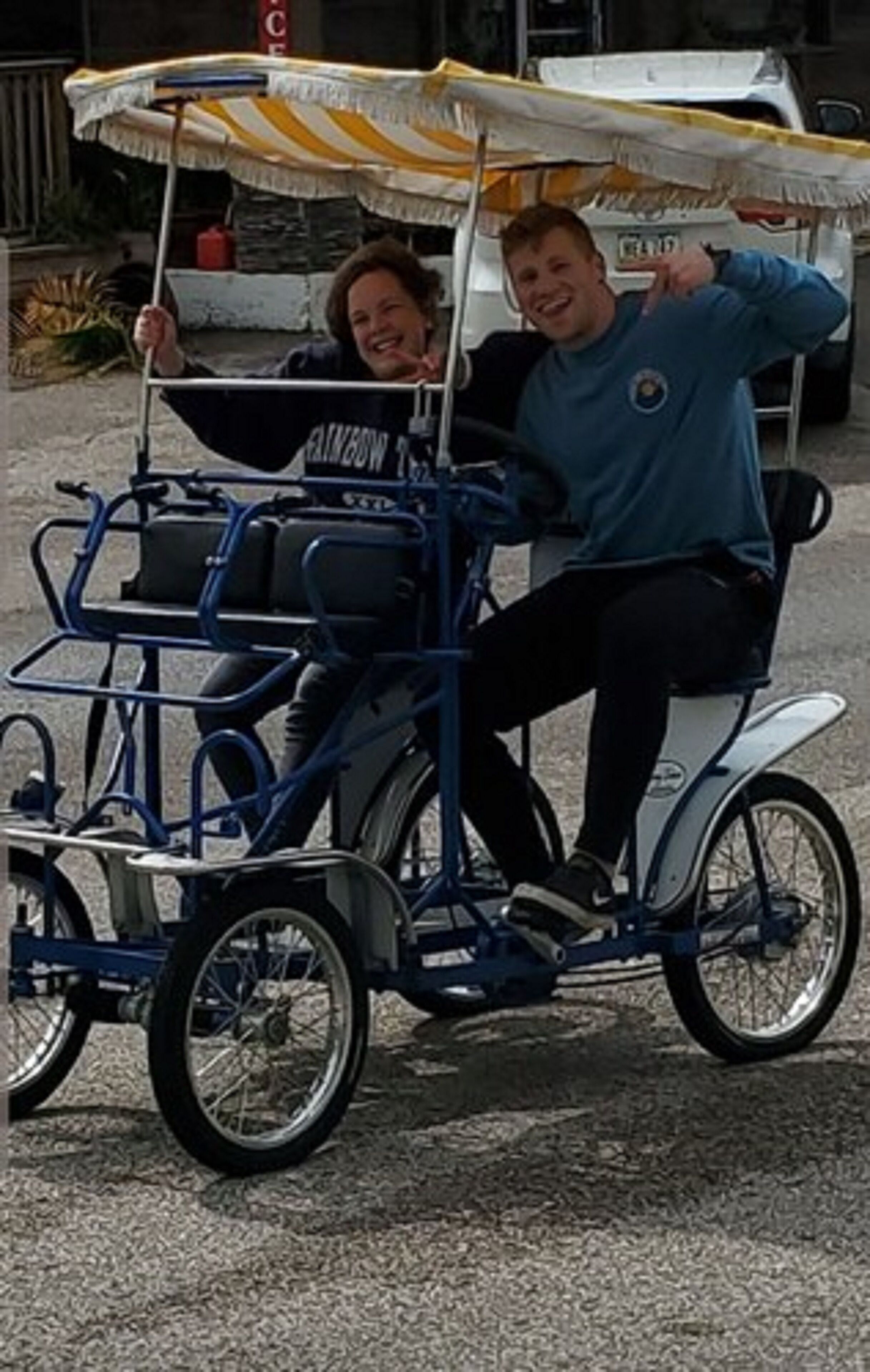 A person riding a bicycle cart with a canopy.