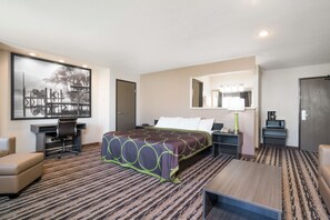 A hotel room with a large bed, a desk with a chair, a small table, and a large mirror. - Super 8 by Wyndham Spirit Lake/Okoboji (Spirit Lake)