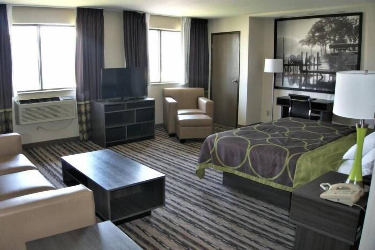 Une chambre d’hôtel équipée d’un lit, d’un bureau, d’une chaise, d’une télévision et d’une fenêtre.