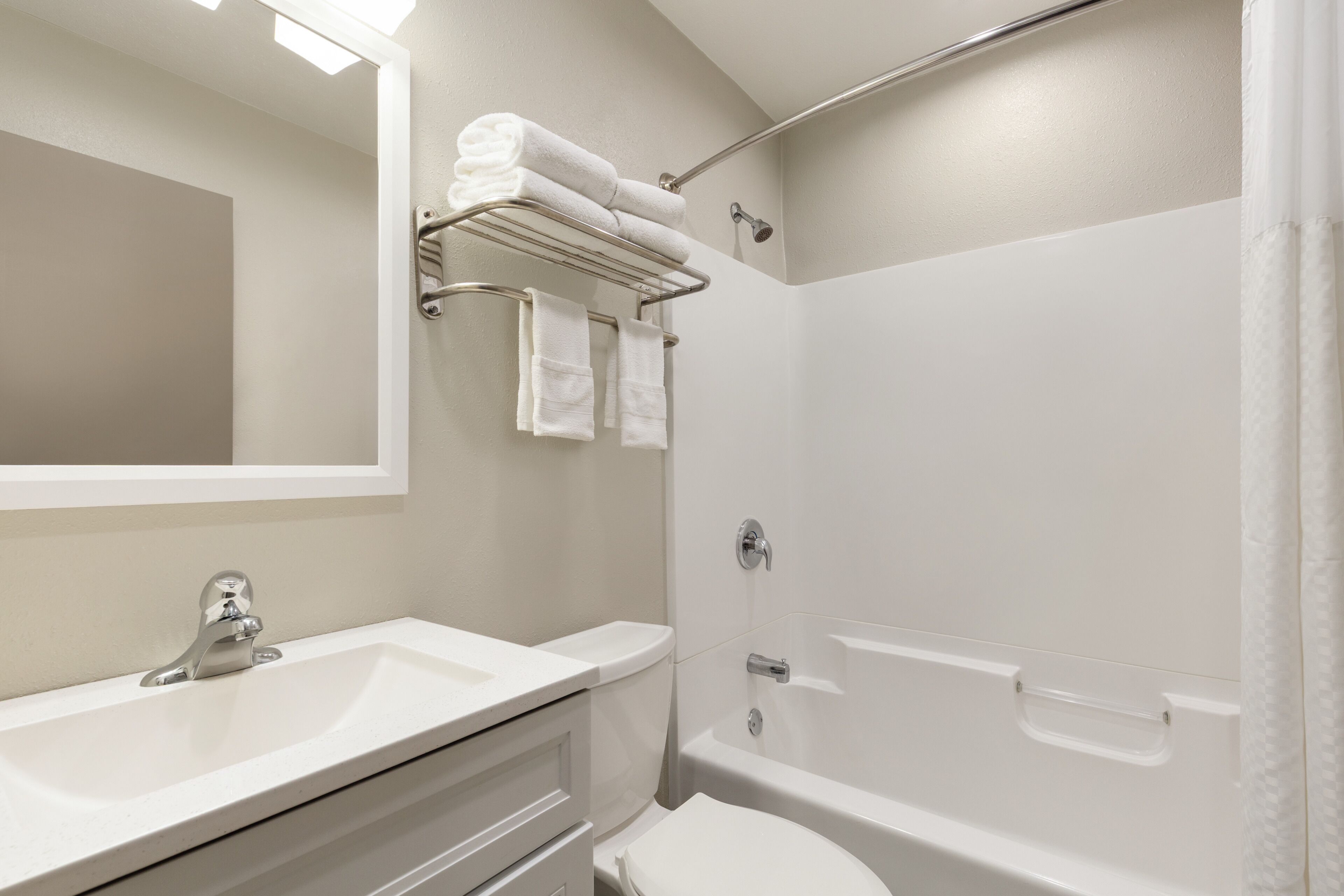 A modern bathroom with a sink, toilet, and shower area.