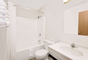 Bathroom features a bathtub, toilet, and sink with a mirror.