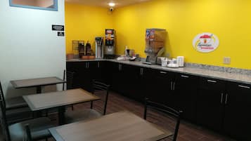 Ein kleines, farbenfrohes Café mit einer gelben Wand, einer Kaffeemaschine und einem Schild für das Superstart-Frühstück.