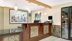 A reception desk with a framed welcome sign, a clock, and a television.