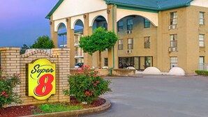 A hotel with a prominent 'Super 8' sign, a brick facade, and a green roof.