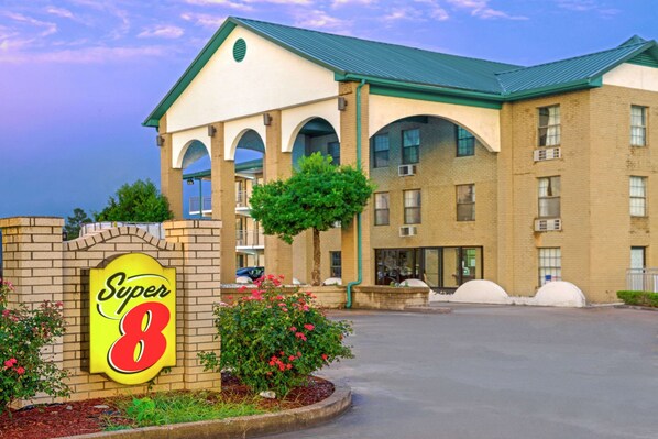 A hotel with a prominent 'Super 8' sign, a brick facade, and a green roof. - Super 8 by Wyndham Lakeland (Arlington)