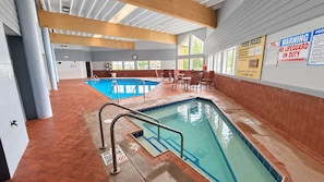 An indoor swimming pool with a tiled floor, a lifeguard station, and pool rules posted on the wall. - Super 8 by Wyndham Wisconsin Dells (Wisconsin Dells)