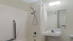 A bathroom with a bathtub, a shower, a sink, and a toilet. - Super 8 by Wyndham Wisconsin Dells (Wisconsin Dells)