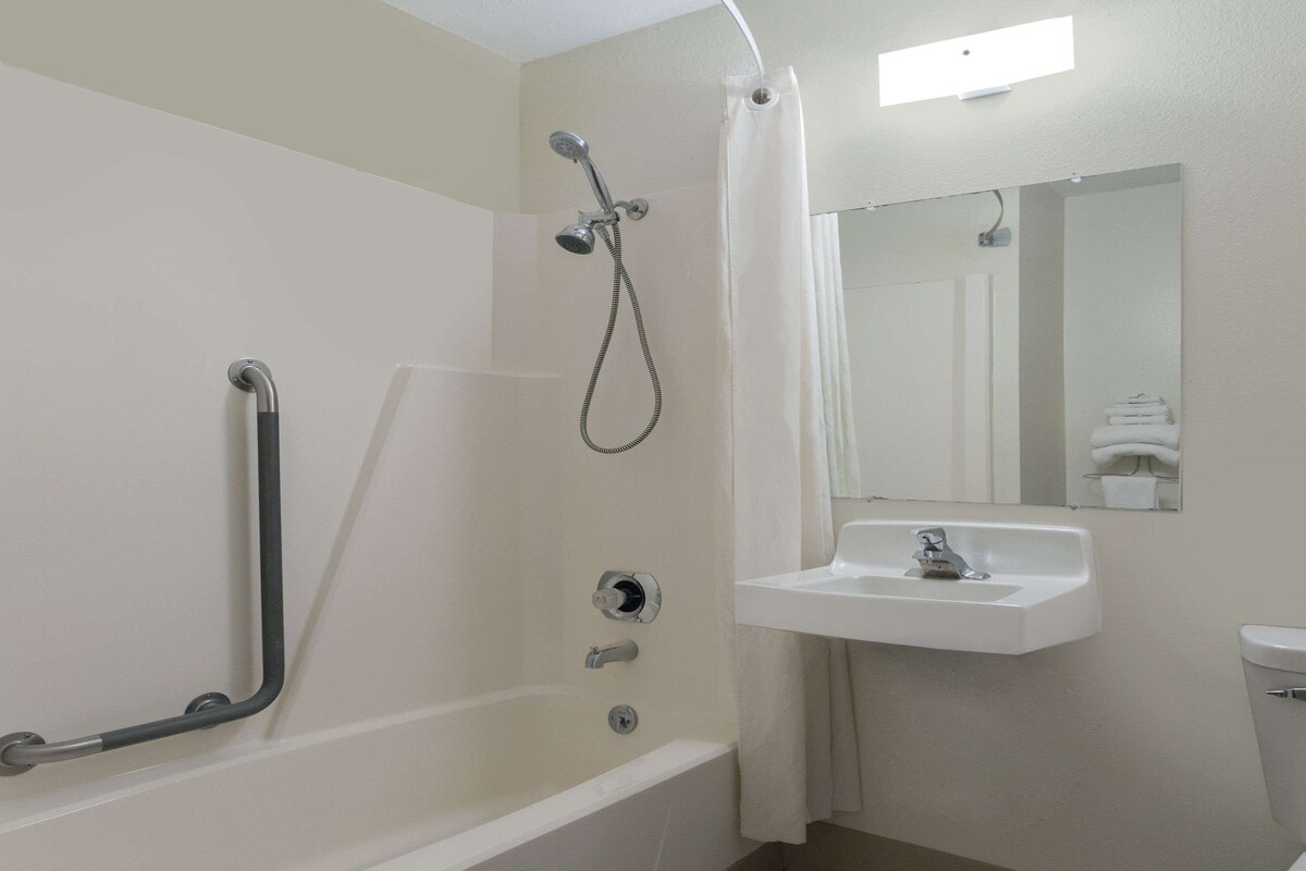 Une salle de bain équipée d’une baignoire, d’une douche, d’un lavabo et de toilettes.
