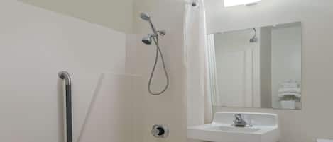 A bathroom with a bathtub, a shower, a sink, and a toilet.