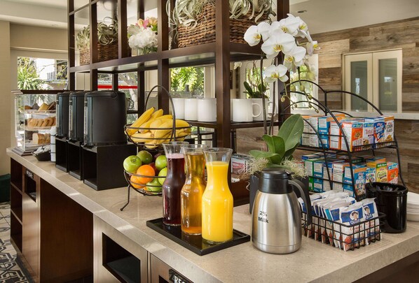 Un buffet de petit-déjeuner proposant divers aliments, boissons et une machine à café.