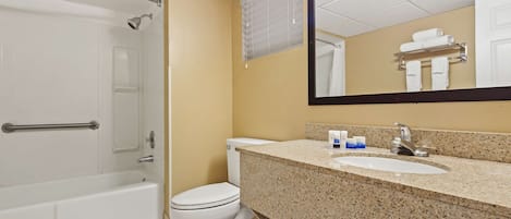 Un baño con bañera, inodoro, lavabo y espejo.