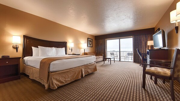 A hotel room with a large bed, a desk, a chair, a TV, and a balcony with a view. - Best Western Fort Myers Waterfront (North Fort Myers)