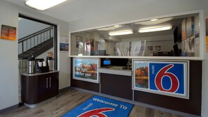 A reception area with a desk, a coffee station, and a welcome mat. - Motel 6 Merrillville, IN (Merrillville)