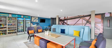 A modern living space with a sofa, chairs, a coffee table, and a snack bar.