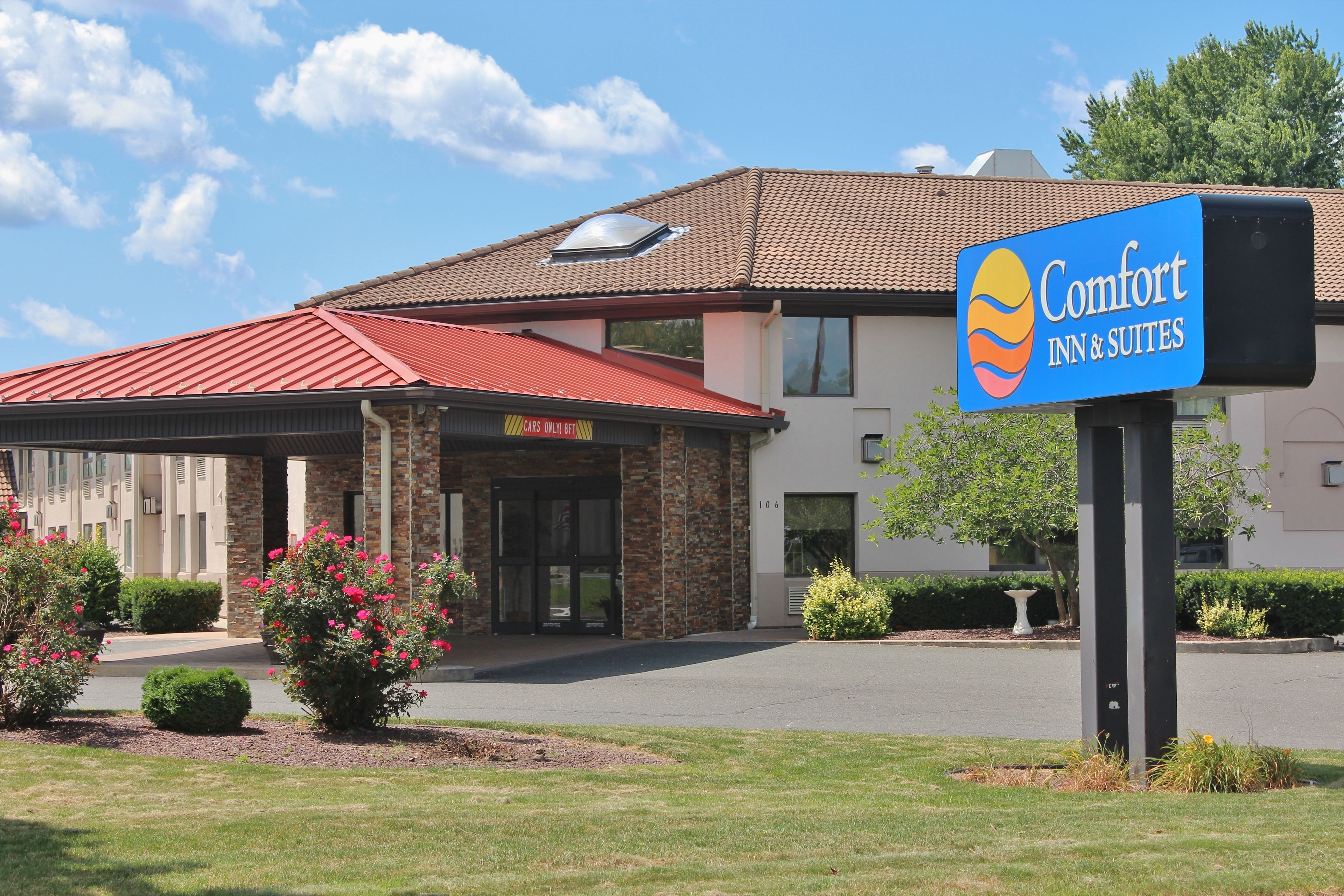 A Comfort Inn & Suites with a red roof, brick exterior, and a signboard.