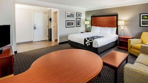 Una habitación de hotel con cama, televisión, escritorio y silla.