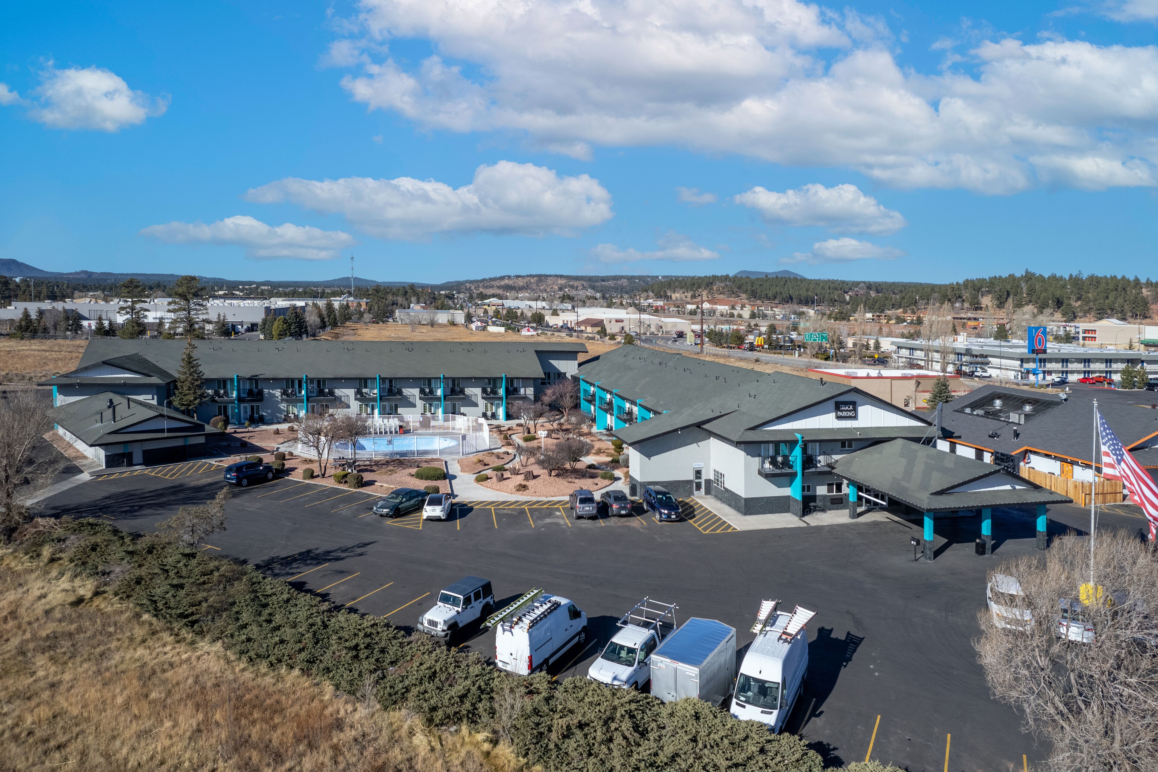 A commercial building with multiple parking spaces and a swimming pool.