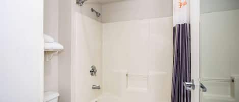 Un baño con bañera, inodoro y cortina de ducha.