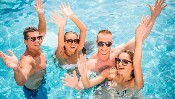 A group of people in a swimming pool with clear blue water. - Western Motel Inn and Suites Hazlehurst (Hazlehurst)