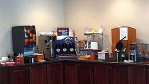 A kitchen area with a coffee machine, a microwave, and a refrigerator. - Western Motel Inn and Suites Hazlehurst (Hazlehurst)