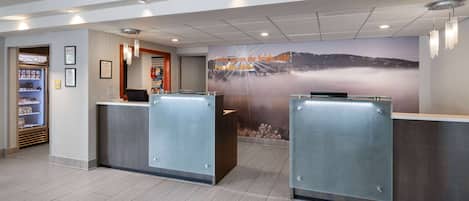 A reception area with a view of a mountain and a sign that reads "wake up on the height side."