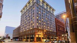 A multi-story hotel with a classic architectural design, featuring a prominent corner entrance and large windows. - Magnolia Hotel Denver, A Tribute Portfolio Hotel (Denver)
