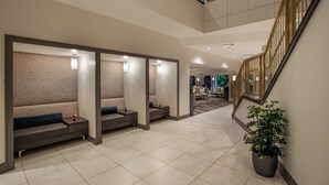 A modern hotel lobby with seating areas, a staircase, and a potted plant. - Magnolia Hotel Denver, A Tribute Portfolio Hotel (Denver)